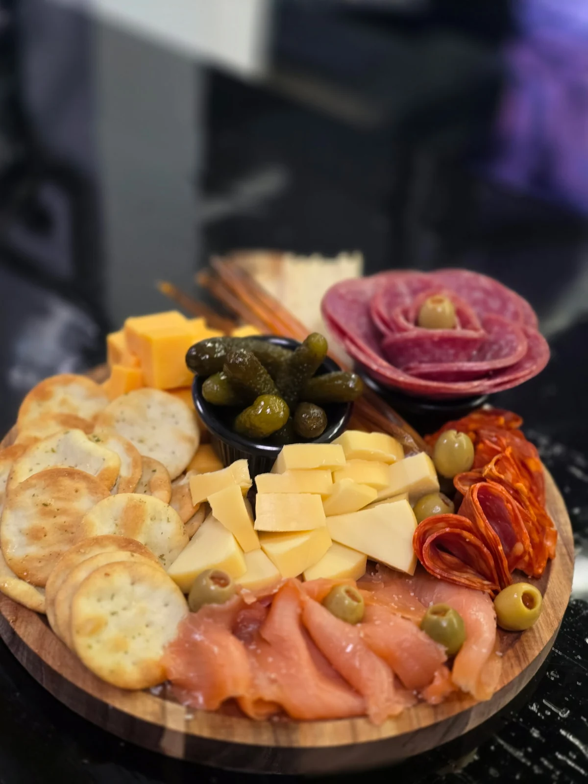 Charcuterie board with meats, cheese, olives, bread, and fruit