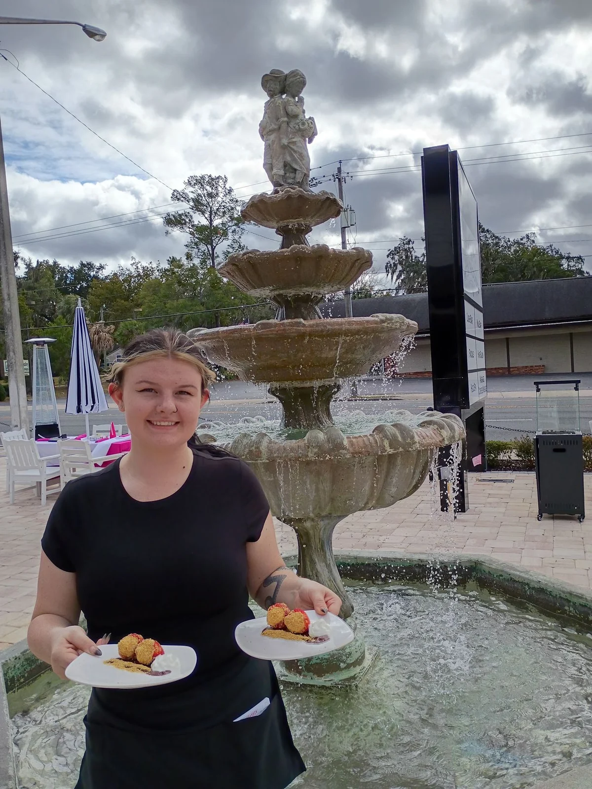 Tea House team member serving tea near the outdoor fountain