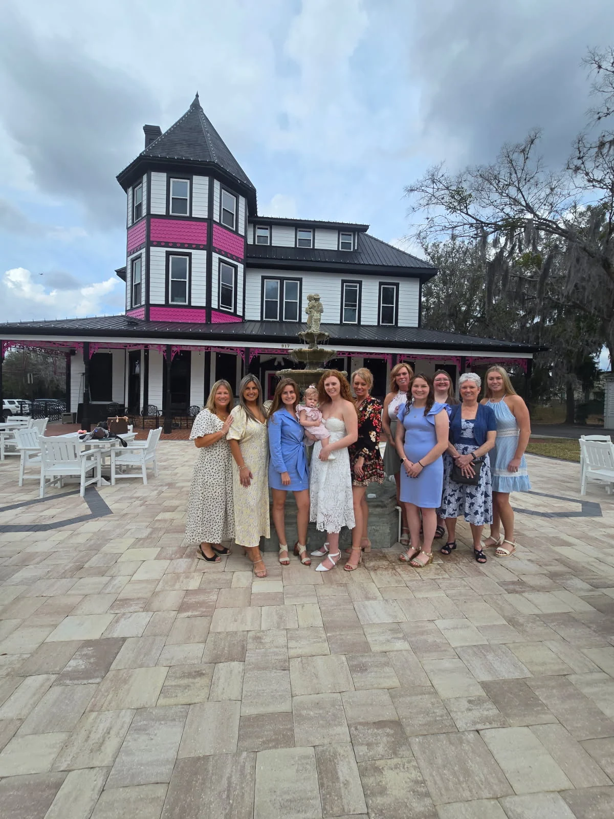 A bridal party posed in front of the 1890 Tea House