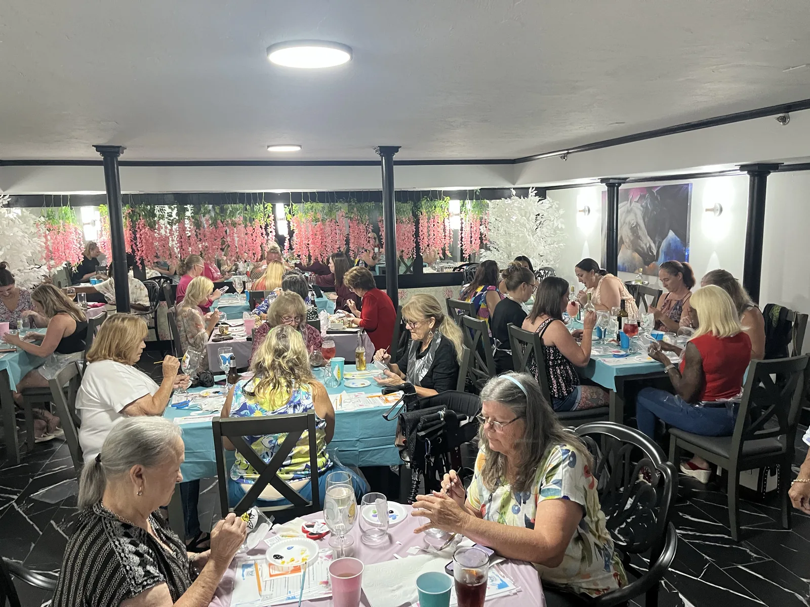 Guests painting wine glasses together in the downstairs event space